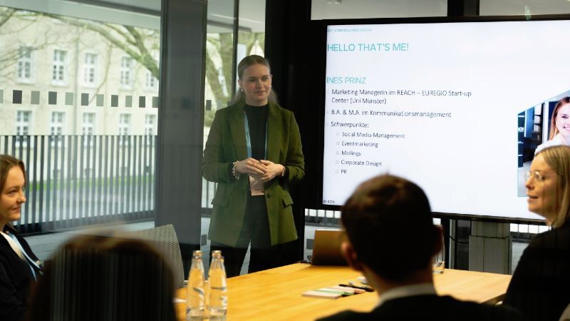 Sitzendes Publikum vor stehender Vortragenden