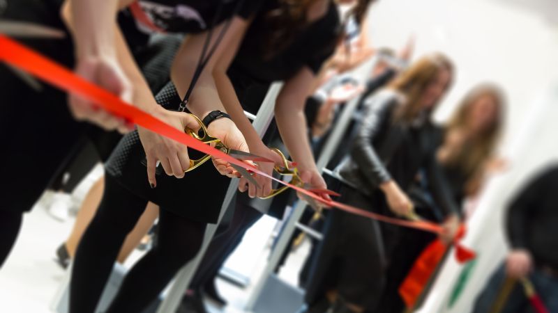 Rotes Band wird mit Schere durchschnitten