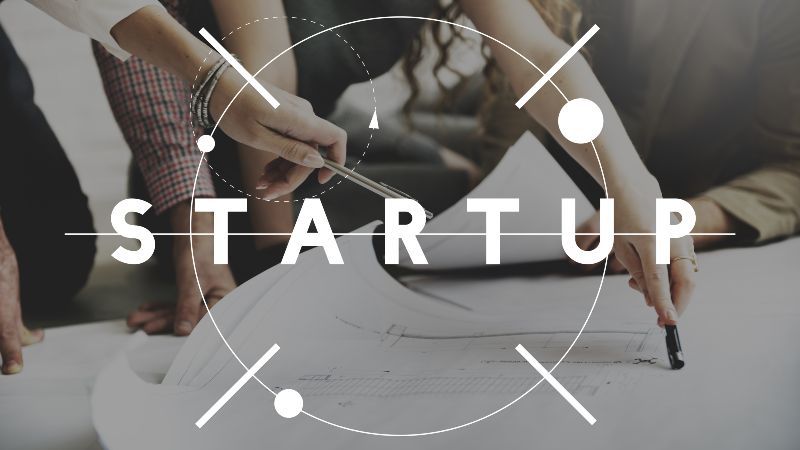 Zwei Personen mit Kugelschreibern in den Händen auf Plan zeigend plus Wort 