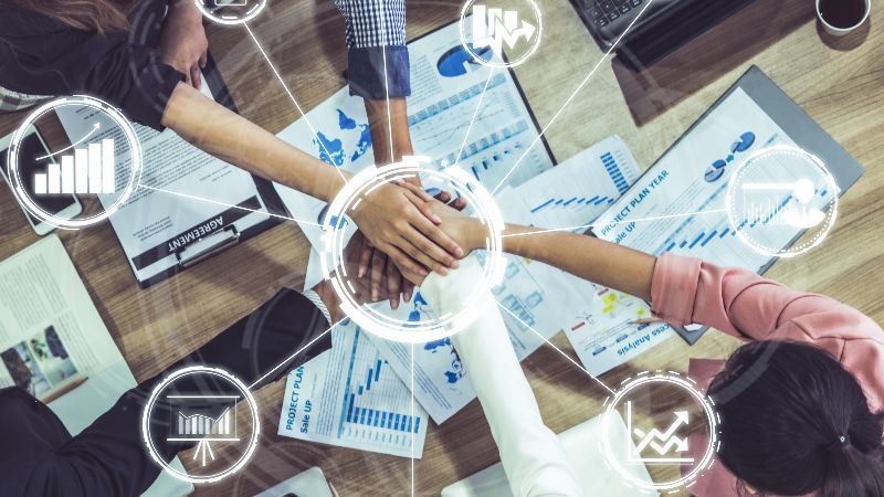 Hände besiegeln Zusammenarbeit mit 9 eingeblendeten Symbolen und einem Kreis in der Mitte