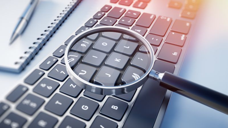 Lupe vergrößert Buchstaben einer Computer-Tastatur