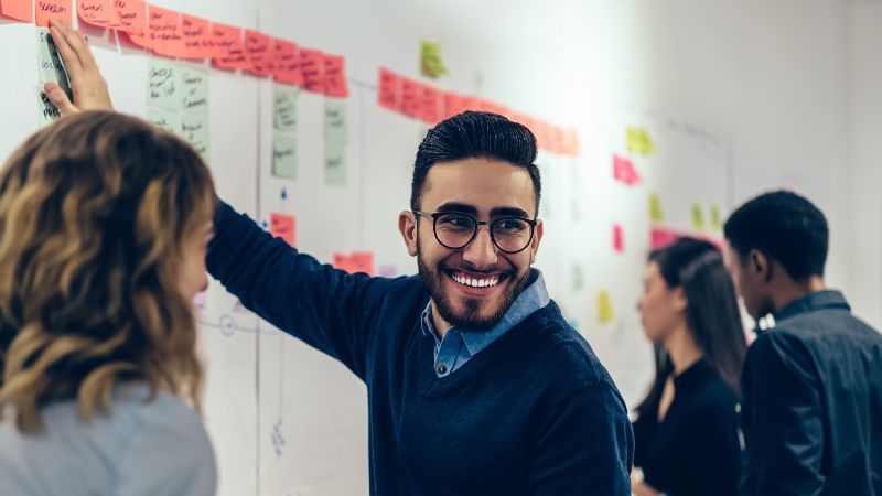 Vier Personen vor Wand mit Post-its