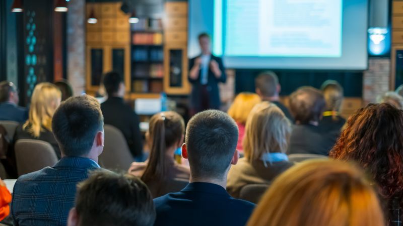 Sitzendes Publikum vor stehendem Vortragenden