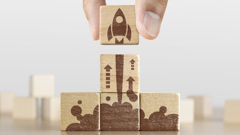 Hand mit Würfeln bedruckt mit kleiner Rakete