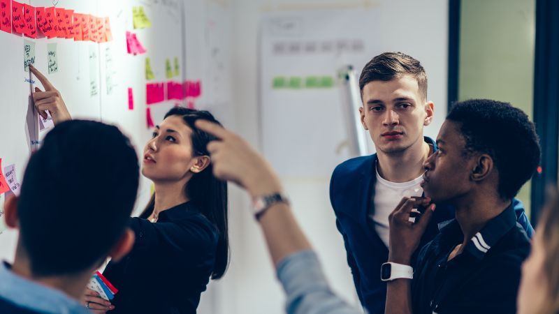 Vier Personen vor Wand mit Post-its